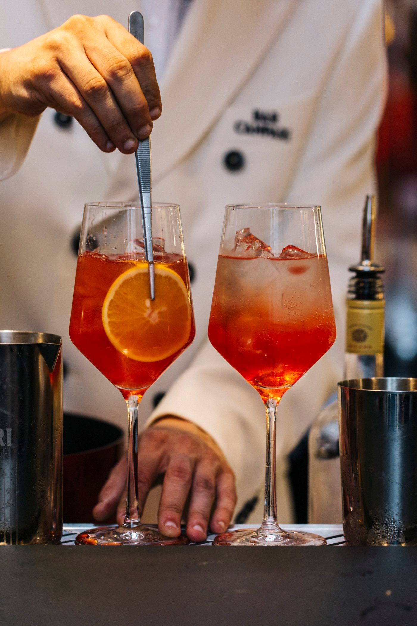 Bartender im Bar-Campari-Dress bereitet Aperol Spritz zu